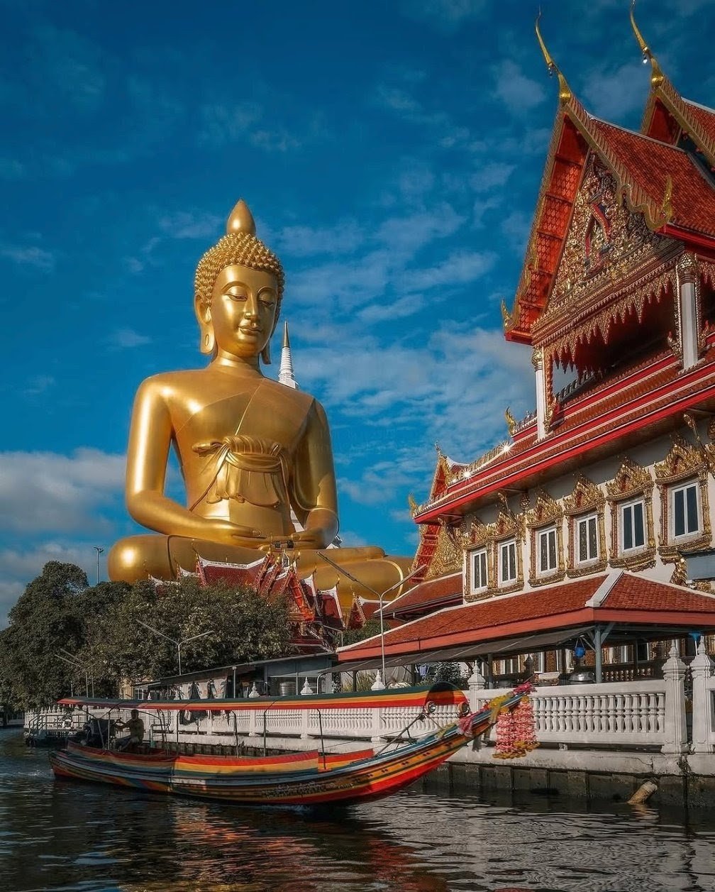 Gran Buda dorado junto a un templo ribereño en Bangkok.