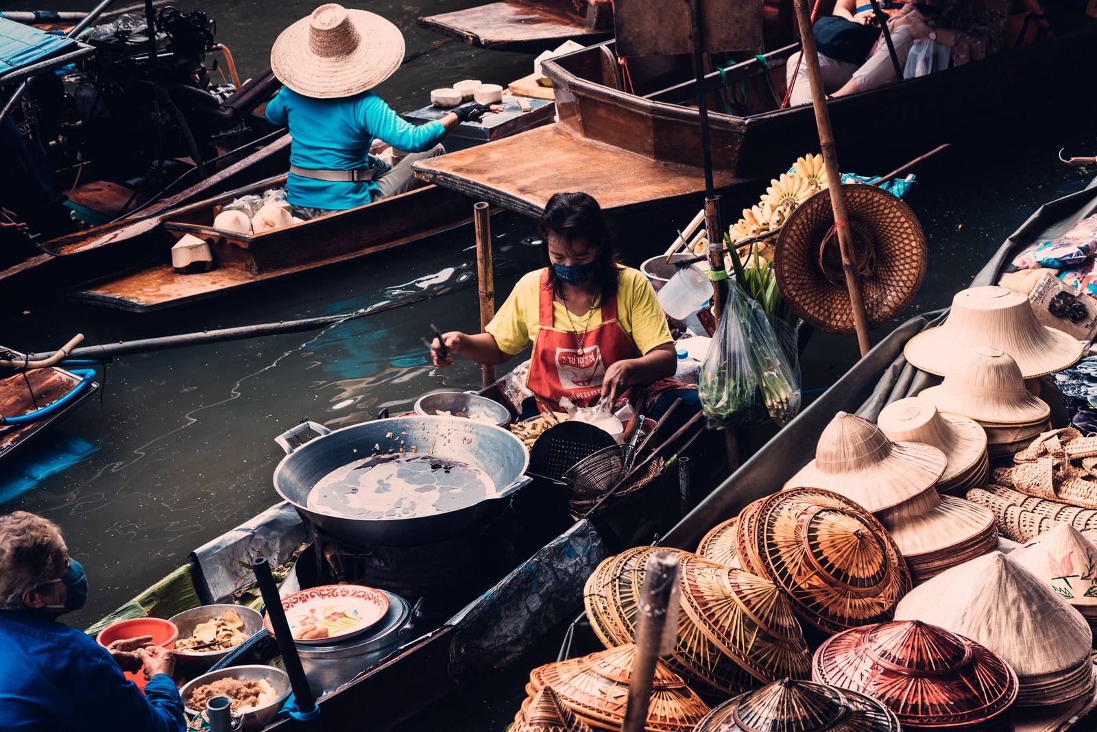 Vendedora preparando comida en una barca en el mercado flotante de Bangkok.